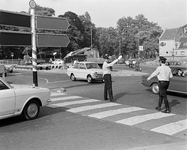 850410 Afbeelding van twee verkeersagenten die het verkeer regelen op de rotonde op het Ledig Erf te Utrecht, vanaf de ...